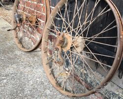 A pair of veteran car front wheels with stub axles.
