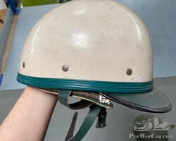 Weißer Helm mit einem Reißverschluss und grünen Details