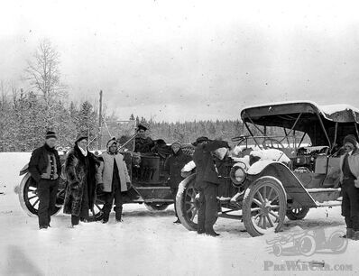 Two early automobiles in the snow