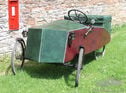 c1934 Mochet Velocar . A French made pedal driven ‘Family’ model velocar. 2 adults powering the machine with space for 2 small infants in the compartment on the back. It has a tubular chassis with a plywood body now covered with a vinyl leatherette. This