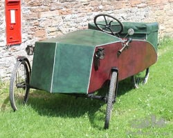 c1934 Mochet Velocar . A French made pedal driven ‘Family’ model velocar. 2 adults powering the machine with space for 2 small infants in the compartment on the back. It has a tubular chassis with a plywood body now covered with a vinyl leatherette. This